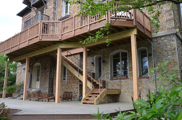 Terrasse en bois sur pilotis maison en pierre
